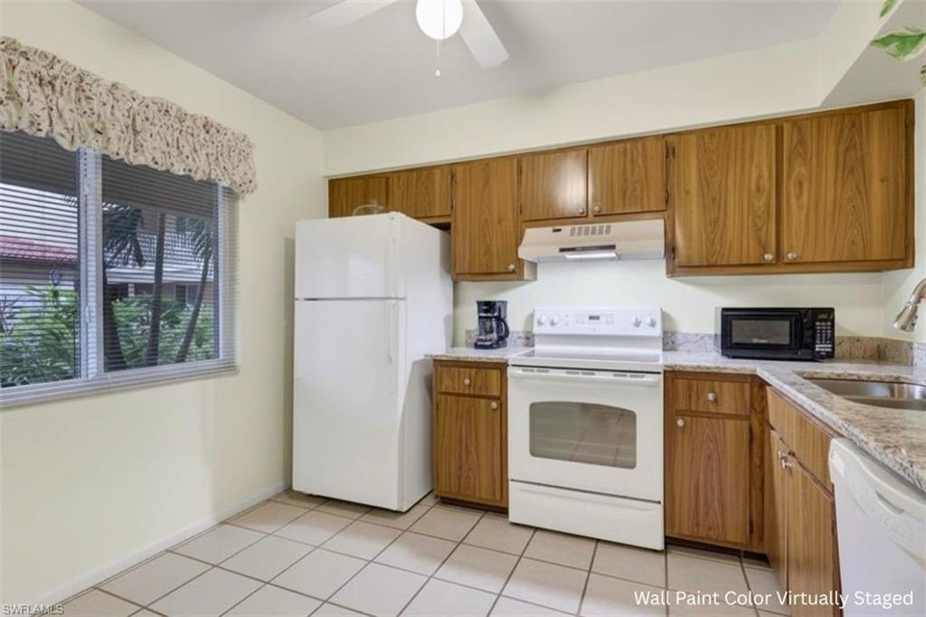 1025 Foxfire Lane, Unit 110 Naples, FL 34104 - Photo 13 of 48 a kitchen with a stove top oven sink and cabinets