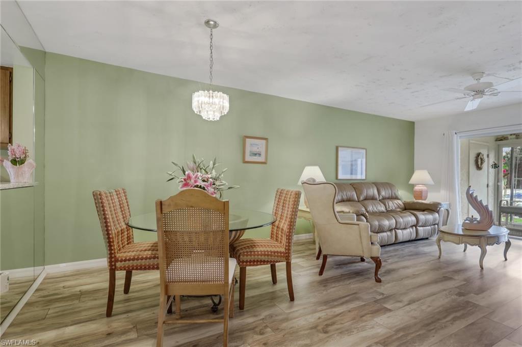 1025 Foxfire Lane, Unit 110 Naples, FL 34104 - Photo 17 of 48 a dining room with furniture a chandelier and wooden floor