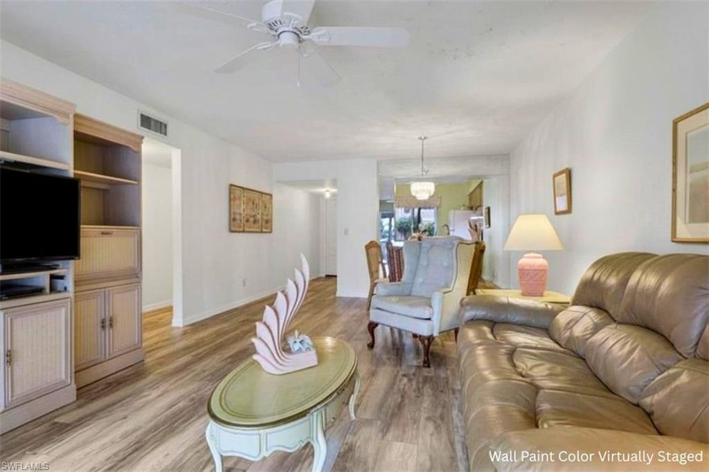 1025 Foxfire Lane, Unit 110 Naples, FL 34104 - Photo 19 of 48 a living room with furniture a flat screen tv and kitchen view
