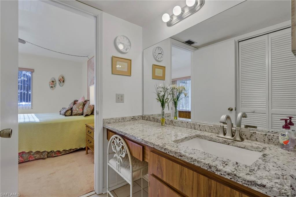 1025 Foxfire Lane, Unit 110 Naples, FL 34104 - Photo 22 of 48 a bathroom with a granite countertop sink and a mirror