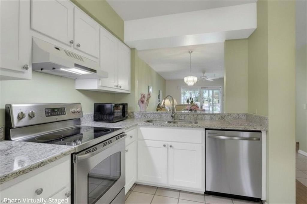 1025 Foxfire Lane, Unit 110 Naples, FL 34104 - Photo 3 of 48 a kitchen with white cabinets and appliances