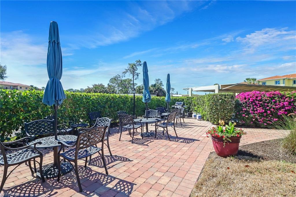1025 Foxfire Lane, Unit 110 Naples, FL 34104 - Photo 31 of 48 a view of a patio with a table and chairs potted plants