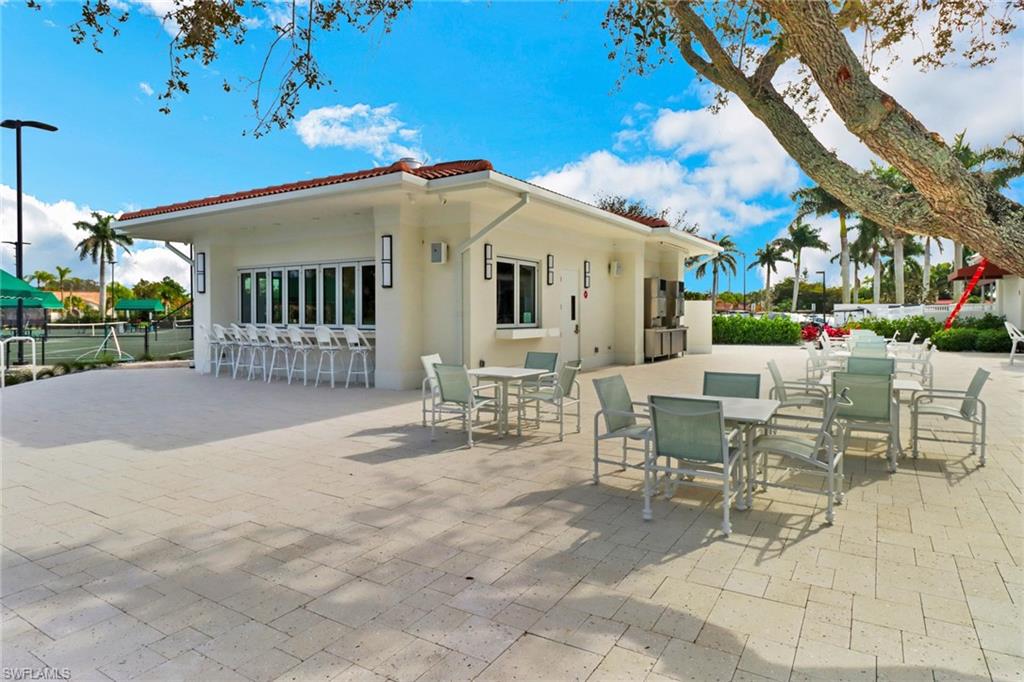 1025 Foxfire Lane, Unit 110 Naples, FL 34104 - Photo 38 of 48 a view of a patio with a table and chairs and potted plants
