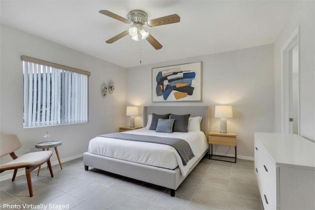 1025 Foxfire Lane, Unit 110 Naples, FL 34104 - Photo 4 of 48 a bedroom with a bed a painting on the wall and a window