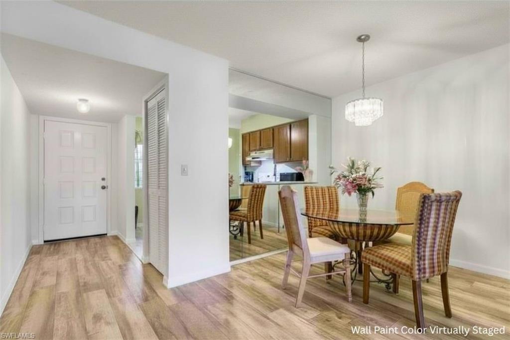 1025 Foxfire Lane, Unit 110 Naples, FL 34104 - Photo 8 of 48 a view of a dining room with furniture and wooden floor