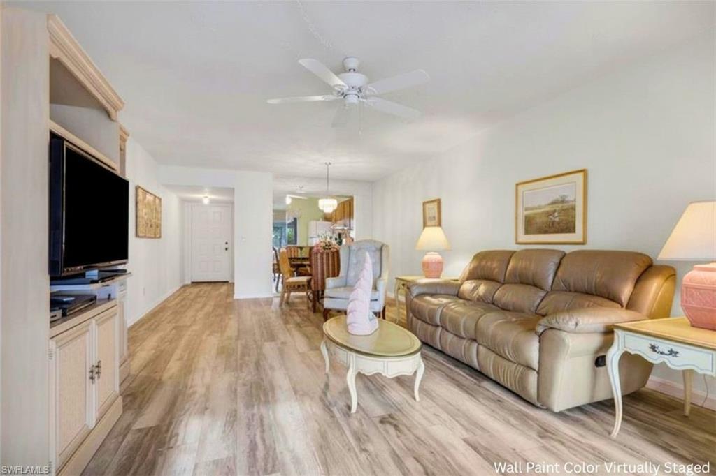 1025 Foxfire Lane, Unit 110 Naples, FL 34104 - Photo 10 of 48 a living room with furniture a flat screen tv and a fireplace