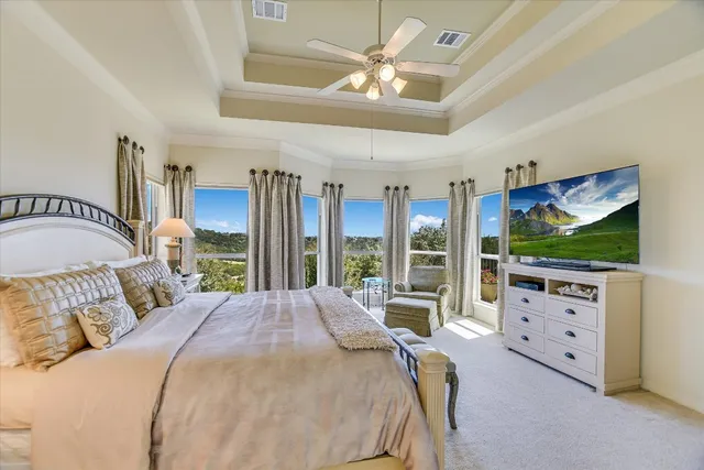a bedroom with a large bed and a flat tv screen on dresser