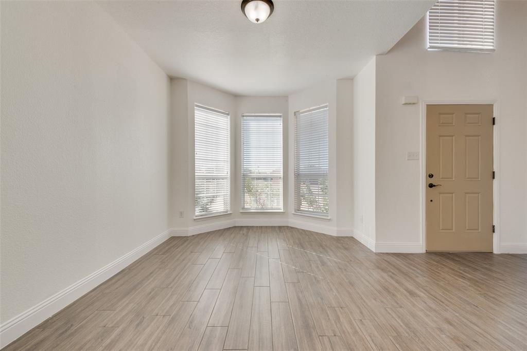 2701 Wildridge Court Fort Worth, TX 76108 - Photo 3 of 26 a view of an empty room with wooden floor and a window