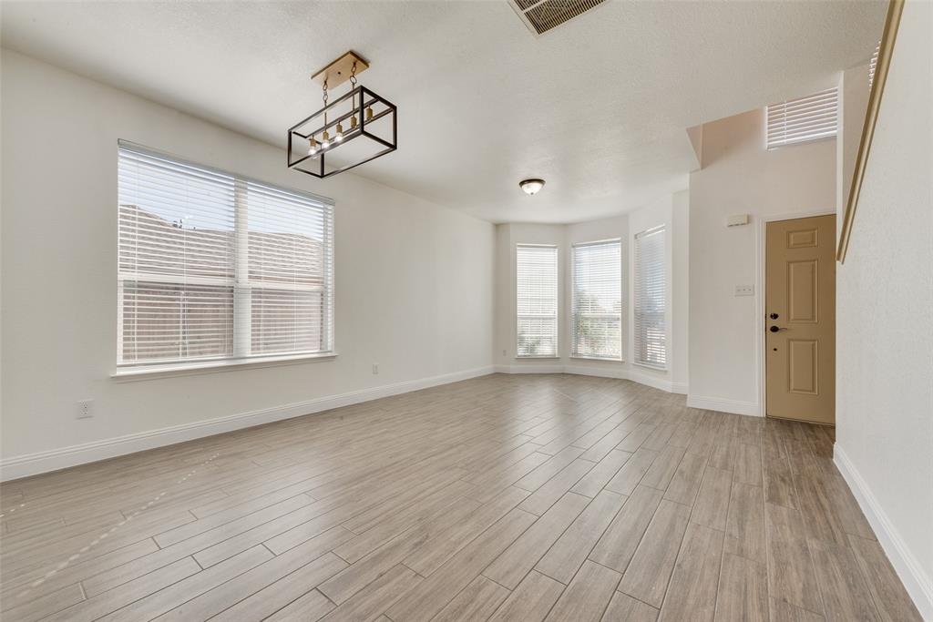 2701 Wildridge Court Fort Worth, TX 76108 - Photo 4 of 26 an empty room with wooden floor cabinet and windows
