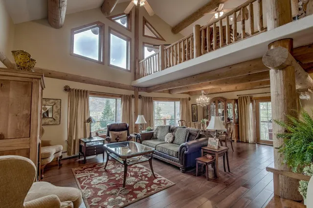 a living room with furniture a window and wooden floor