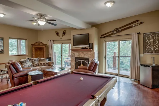 a living room with furniture a flat screen tv and a large window