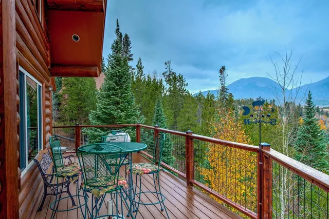 a view of a balcony with chairs and wooden fence