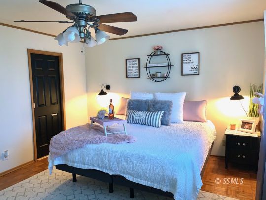 217 Rancho Street Ridgecrest, CA 93555 - Photo 16 of 25 a bedroom with a bed and a chandelier