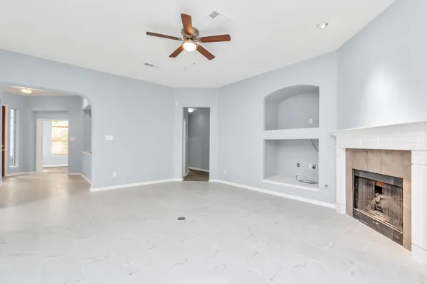 a view of an empty room with a fireplace and a window
