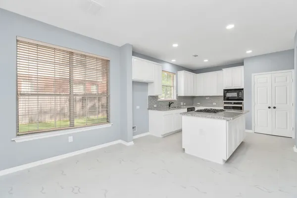 a kitchen with white cabinets and white appliances
