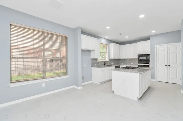 a kitchen with white cabinets and white appliances