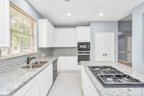 a kitchen with a stove a sink and a refrigerator