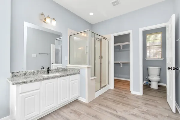 a bathroom with a granite countertop sink toilet and shower