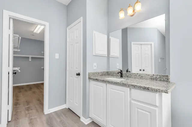 a bathroom with a granite countertop sink and a mirror