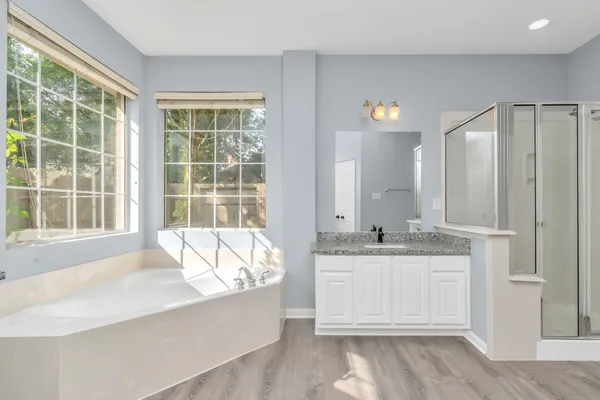 a spacious bathroom with a granite countertop tub sink and mirror