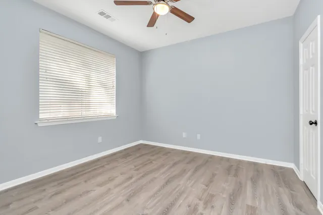 wooden floor in an empty room with a window
