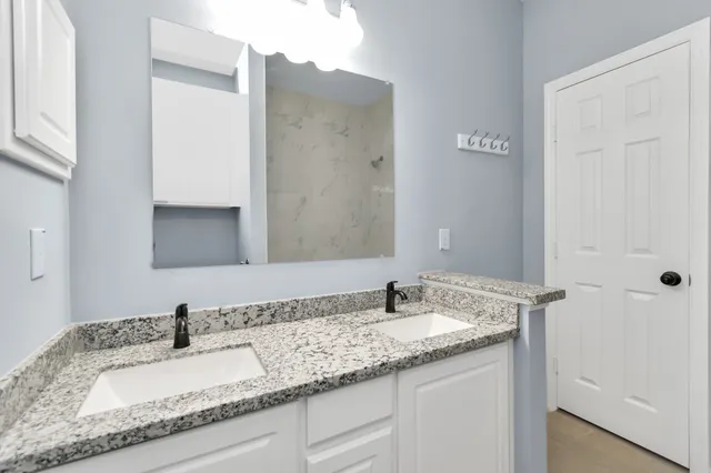 a bathroom with a granite countertop sink and a mirror