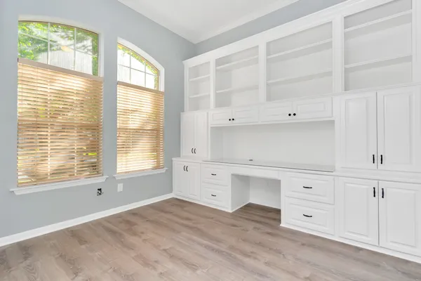 a view of an empty room with a window and cabinet