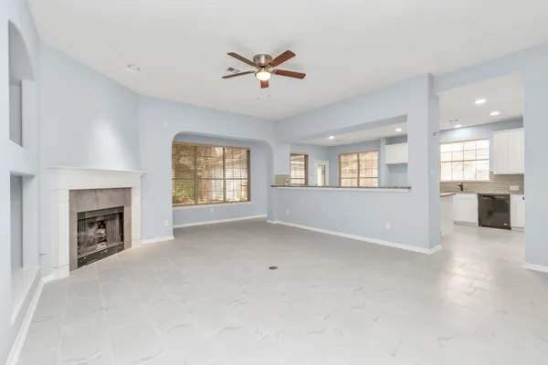an empty room with windows and fireplace