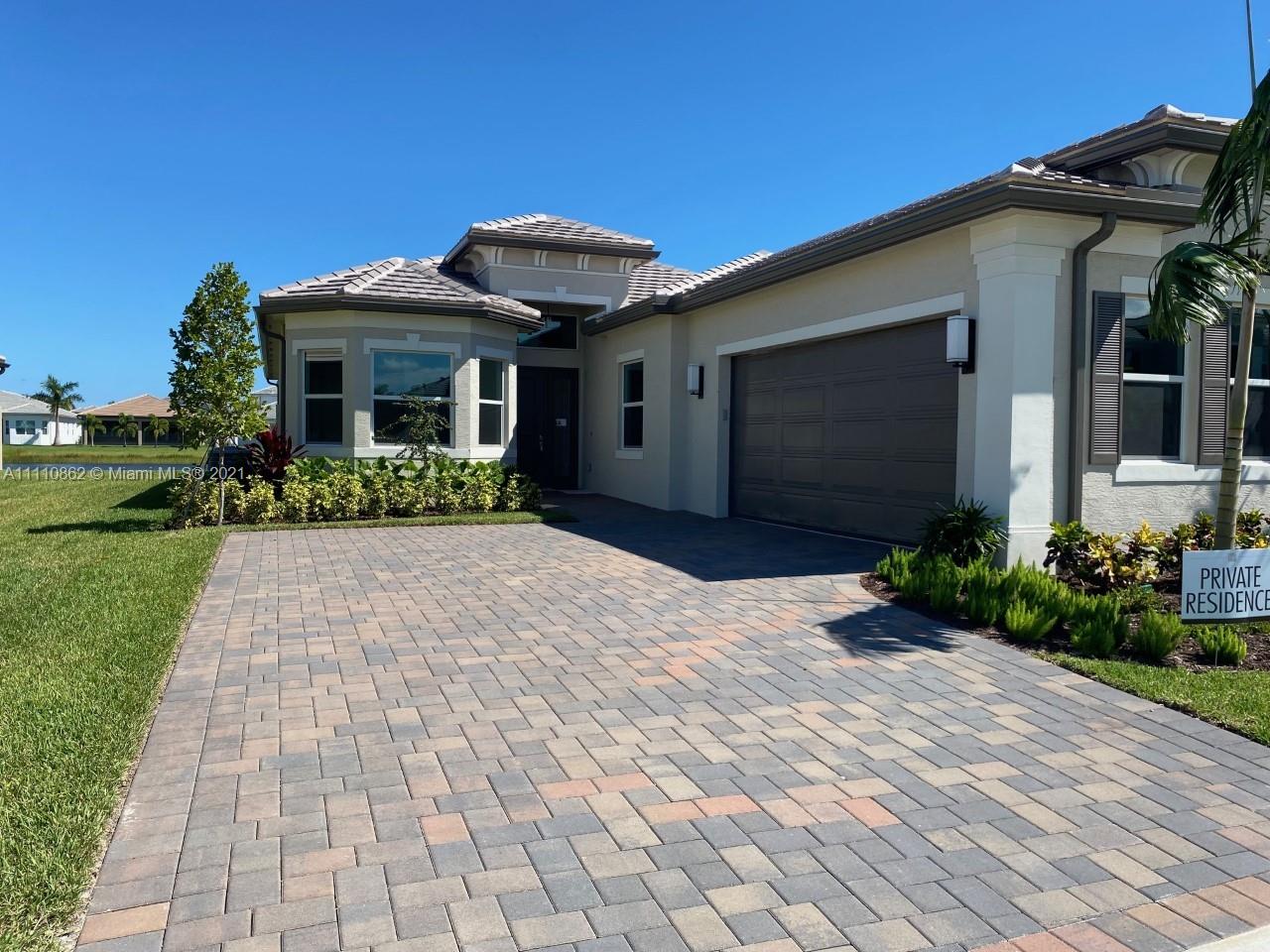 Polo Trace Delray Beach, FL 33446 - Photo 2 of 40 a front view of a house with a yard and potted plants