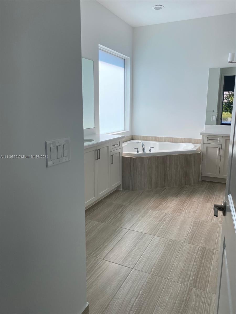 Polo Trace Delray Beach, FL 33446 - Photo 18 of 40 a bathroom with a tub sink and mirror