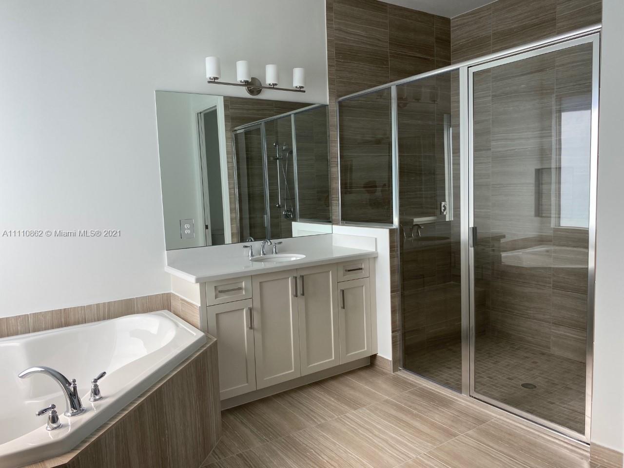 Polo Trace Delray Beach, FL 33446 - Photo 20 of 40 a bathroom with a shower sink and mirror