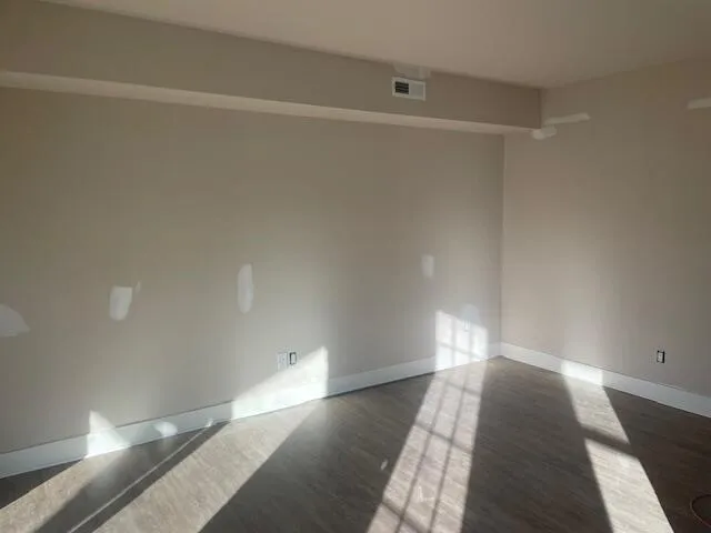 a view of a room with wooden floor and white walls