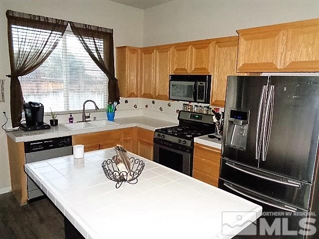 5555 Tappan Drive Reno, NV 89523 - Photo 9 of 11 a kitchen with stainless steel appliances a stove sink microwave and refrigerator