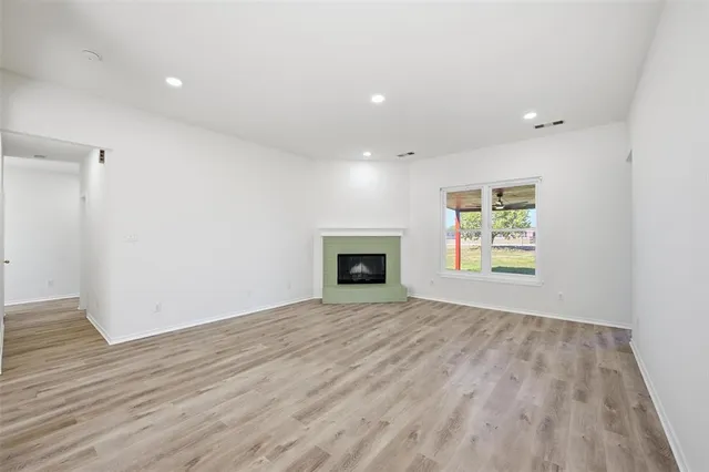 an empty room with windows and fireplace