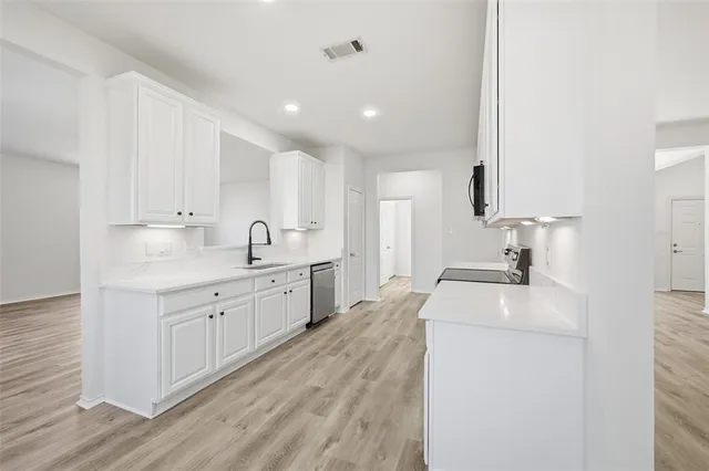 a kitchen with sink stove and refrigerator
