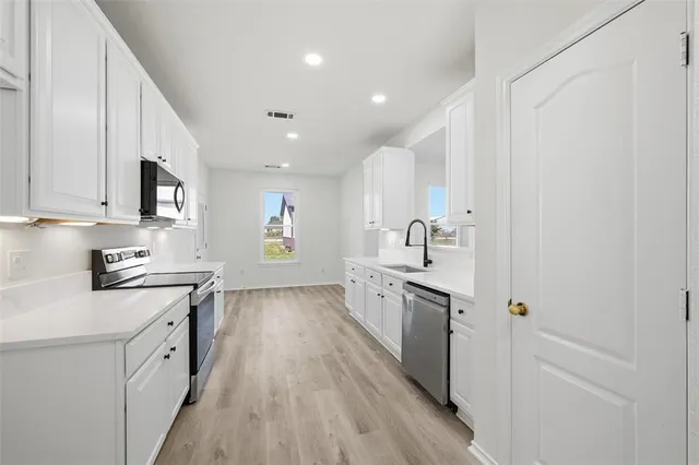 a kitchen with cabinets wooden floor and a sink