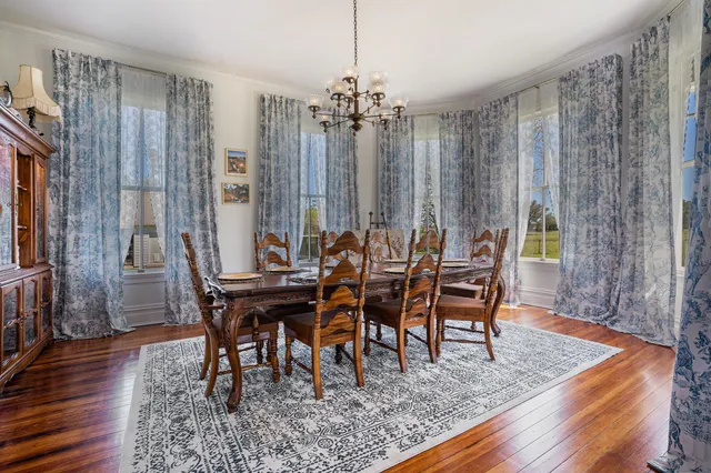 a kitchen with a refrigerator wooden floor and white cabinets