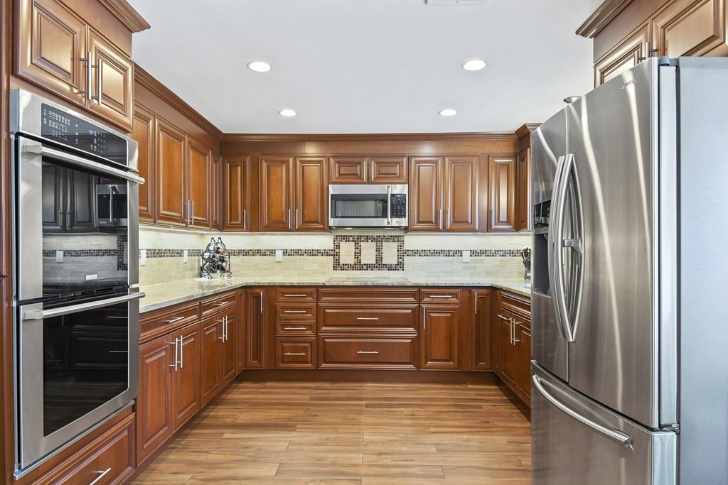 33 Old Farm Road Reading, MA 01867 - Photo 12 of 42 a kitchen with stainless steel appliances granite countertop a refrigerator and a stove top oven