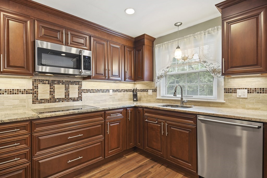 33 Old Farm Road Reading, MA 01867 - Photo 14 of 42 a kitchen with stainless steel appliances granite countertop a sink stove and microwave