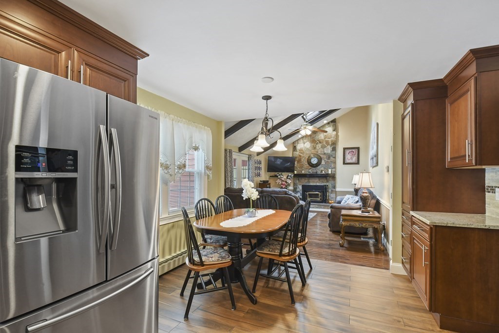 33 Old Farm Road Reading, MA 01867 - Photo 16 of 42 a kitchen with stainless steel appliances a refrigerator a stove a dining table and chairs