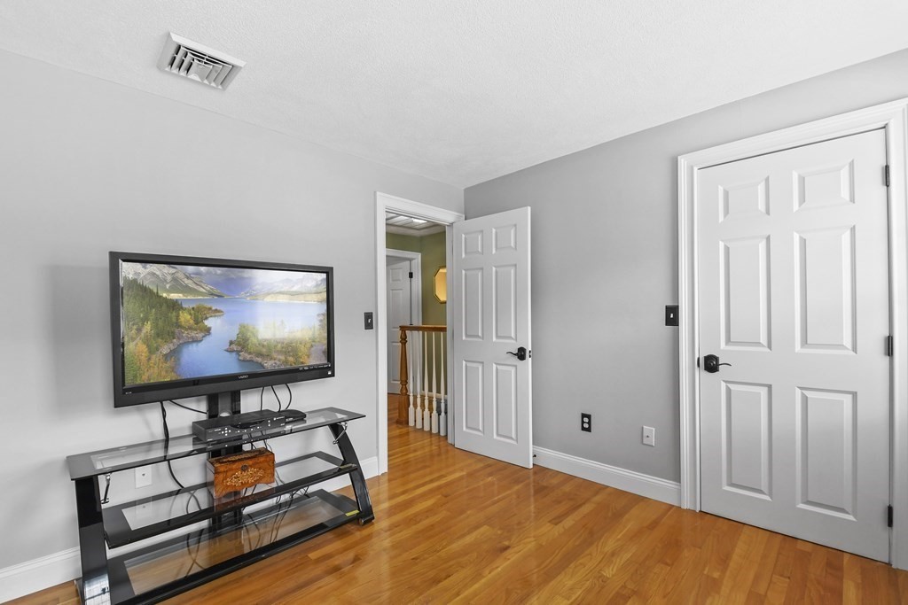 33 Old Farm Road Reading, MA 01867 - Photo 34 of 42 a living room with furniture and a flat screen tv