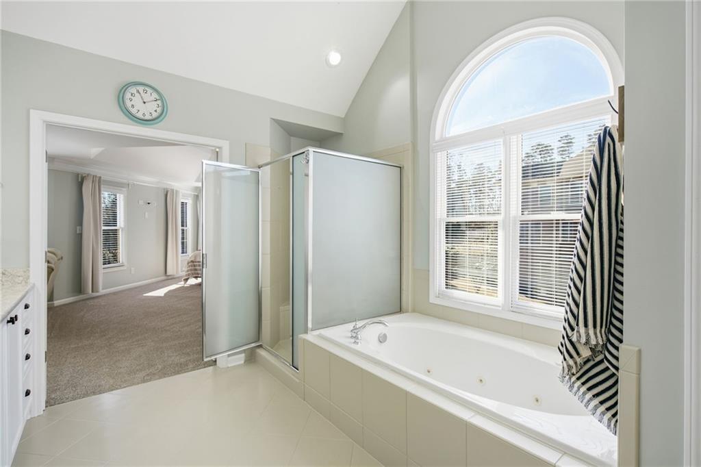 1830 Callaway Ridge Drive Northwest Kennesaw, GA 30152 - Photo 31 of 60 a bathroom with a bathtub a shower a sink and a window