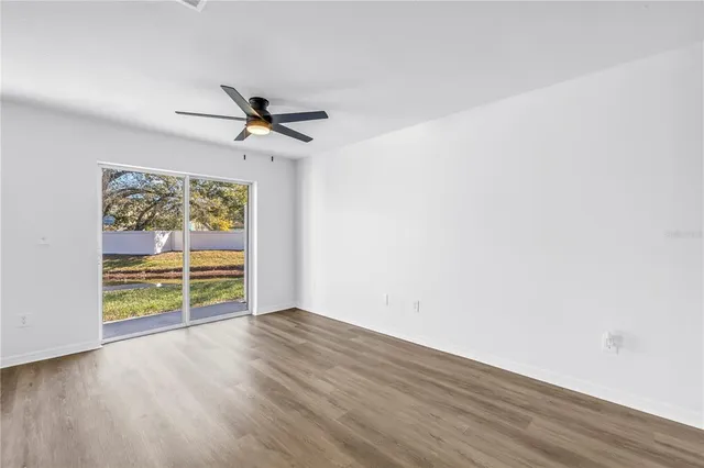 a view of a kitchen with kitchen island a sink wooden floor and white cabinets