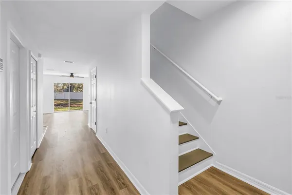 a view of a kitchen with wooden floor electronic appliances and cabinets