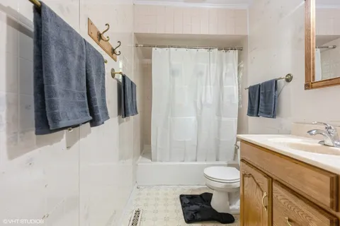 a bathroom with a toilet sink a mirror a vanity and shower