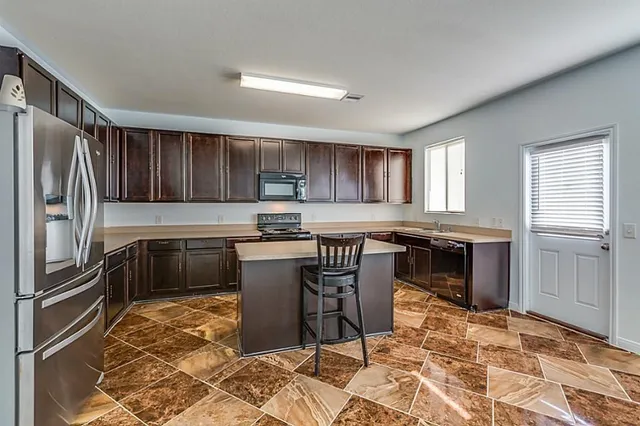 a kitchen with stainless steel appliances granite countertop a stove a sink a microwave and a refrigerator