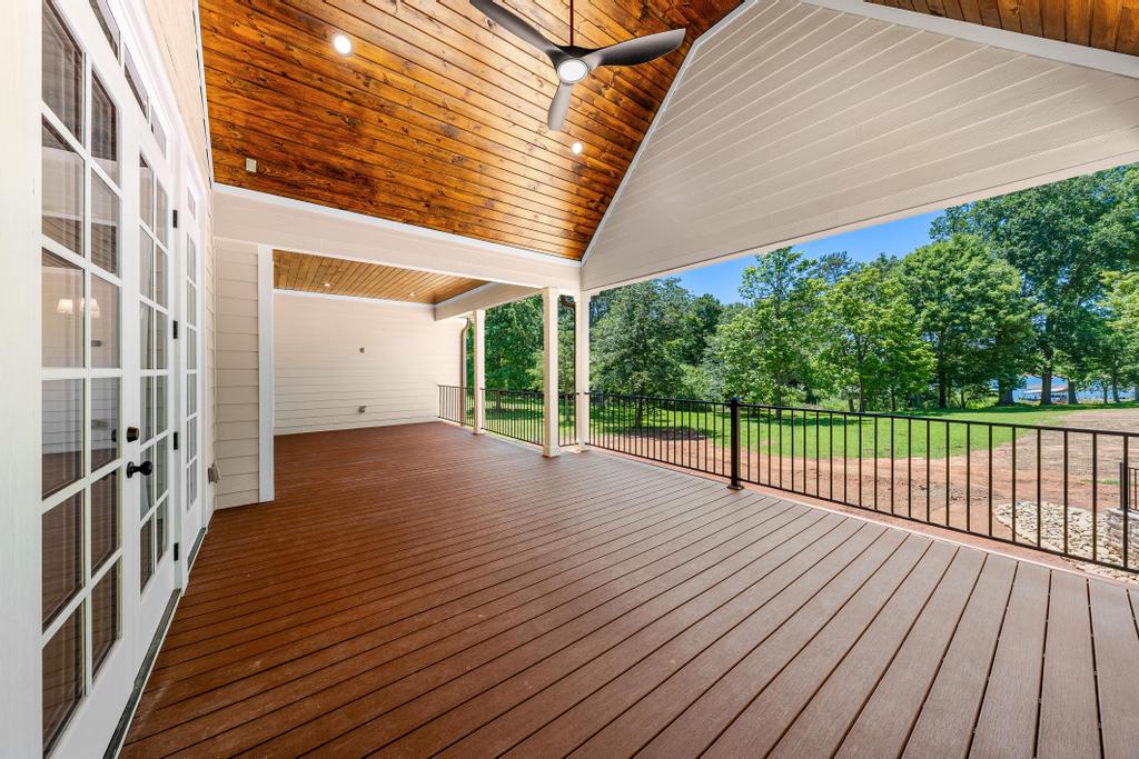 707 Vickery Street Extension Hartwell, GA 30643 - Photo 15 of 50 A spacious covered deck with wood-paneled ceilings extends to embrace verdant surroundings and a distant body of water.
