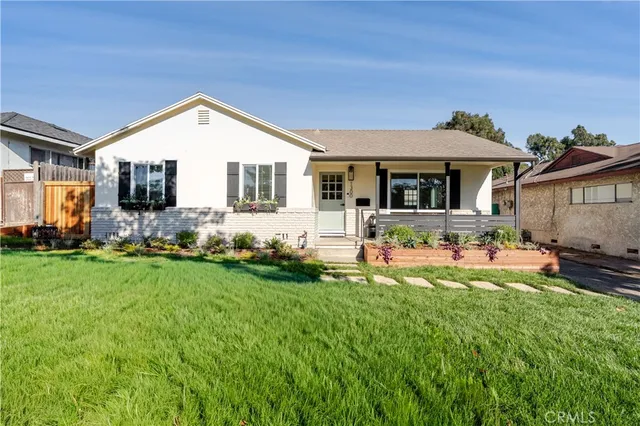 a front view of a house with a yard and outdoor seating