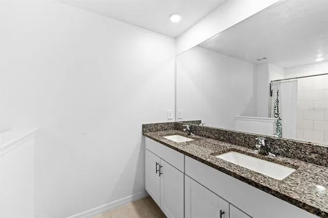 a bathroom with a granite countertop sink and a mirror