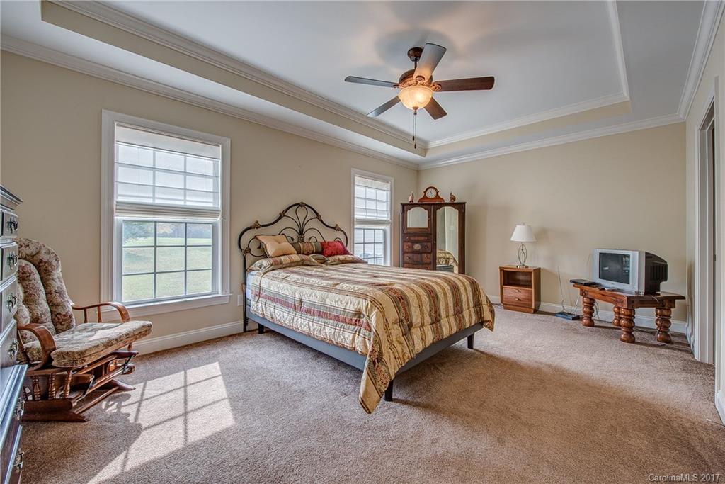 1072 Arabian Farm Road, Unit 9 Clover, SC 29710 - Photo 9 of 24 a bedroom with a bed a chair and a chandelier